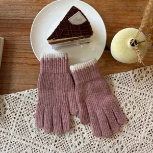Detailed view of winter knit gloves in pink with cream ribbed cuffs, cozy lifestyle flat lay.