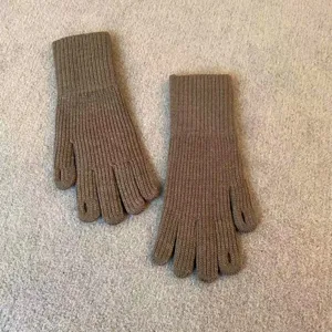 Detail shot of winter warm knit gloves, solid khaki color with finger holes for phone use.