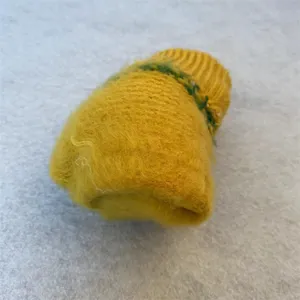 Cozy winter yellow knitted gloves detail view, warm soft fuzzy wool material for cold days.