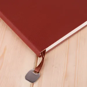 Detailed view of the leather A5 business notebook with ribbon bookmark and metal pendant.