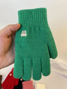 Detailed view of green knitted five-finger gloves featuring cute bear embroidery design.