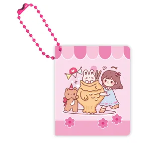 Détail d'un mini carnet de poche avec chaîne de perles roses et couverture illustrée.