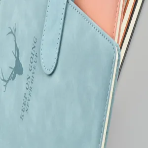 Primo piano dettaglio del taccuino in pelle PU blu con motivo di cervo e citazione.