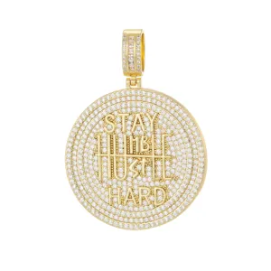 Detailed view of gold plated iced-out hip-hop pendant with Stay Humble Hustle Hard engraving