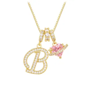Detailansicht der Goldkette mit Zirkonia-Buchstabe B und rosa Herz-Planeten-Anhänger.