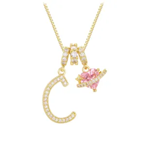 Detailansicht des goldenen C-Buchstabenanhängers und des funkelnden rosa Herz-Zirkon-Anhängers