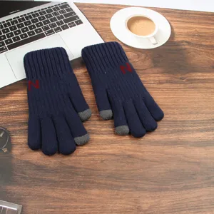 Vue détaillée de gants tactiles en tricot bleu foncé mettant en valeur le bout des doigts.