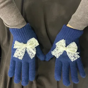 Gemütliche blaue Strickhandschuhe mit weißen Spitzen Schleifen und Perlen für Damen.