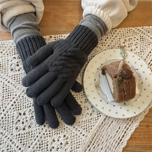 Gros plan de gants d'hiver tricotés gris foncé, montrant une texture douce et agréable.