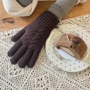 Gros plan de gants en tricot marron avec motif texturé épais pour un hiver bien chaud.