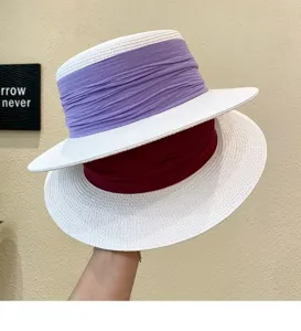 Detail view of a French retro flat-top straw hat with purple and red fabric ribbons.