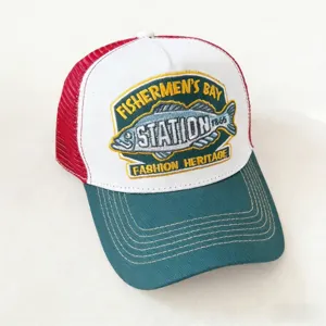 Close-up detail of vintage style trucker hat with embroidered fish badge, mesh back and curved brim.