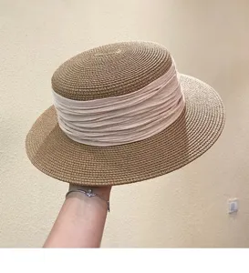 Close-up detail of French retro flat top straw hat with elegant pink ribbon decoration.