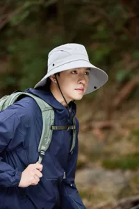 Detail shot of grey outdoor sun hat with breathable mesh and wide brim worn by hiker.
