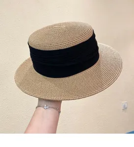 Detailed view of the vintage flat-top straw hat with black ribbon, perfect for summer travel.