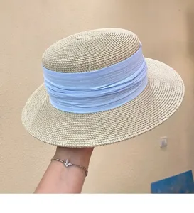 Close-up of French vintage flat-top straw hat with light blue ribbon, summer sun hat.