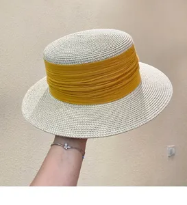 Detail view of a French vintage flat top straw hat with yellow ribbon for summer vacation travel.