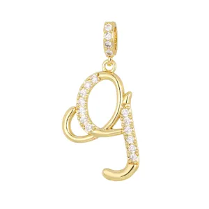 Primo piano di un ciondolo a lettera g placcato oro con pietre di zircone scintillanti.