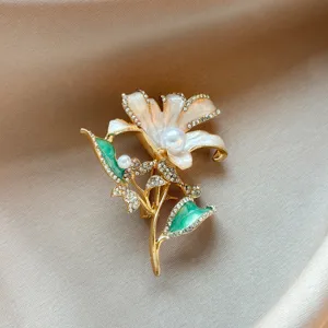 Elegant lily flower brooch with sparkling rhinestones and pearls, stylish suit accessory.