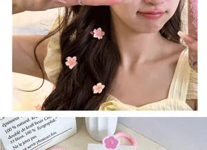 Detailed view of cute pink cherry blossom hair clips worn by model and a matching elastic hair tie
