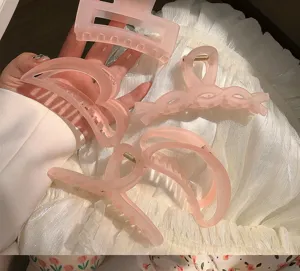 Gros plan montrant la texture gelée mate de quatre grandes pinces à cheveux roses