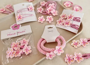 Close-up of pink cherry blossom hair accessories including clips and ties.