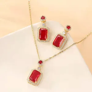 Detailed view of red rectangle gemstone necklace and earrings set with gold finish