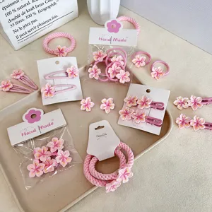 Set of pink cherry blossom hair clips and hair ties for cute summer styling.
