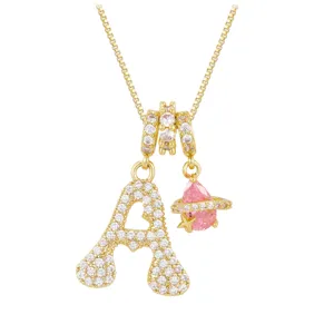 Close-up of gold letter A pendant necklace with sparkling pink zircon planet charm.