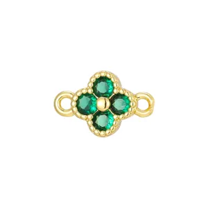 Close-up of a gold-plated clover pendant with green zircon stones and double loops