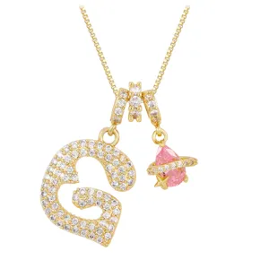 Detailed close-up of gold necklace featuring a zircon heart letter G and pink star pendant