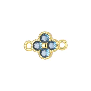 Detailed close-up of a four-leaf clover pendant with blue zircons and gold beaded edges.