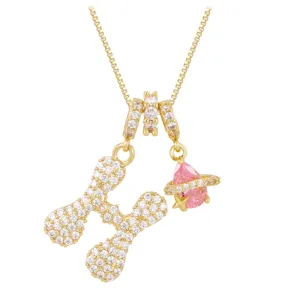 Golden necklace with iced-out letter H pendant and pink planet crystal charm detail
