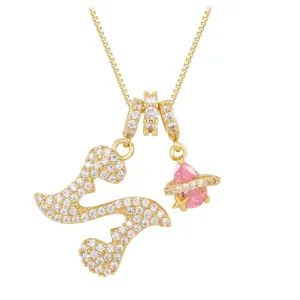 Close-up of gold-plated necklace with zircon-studded letter S and pink planet pendant