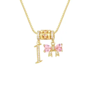 Detail einer Goldkette mit herzförmiger rosa Zirkon-Schleife und Ziffer-1-Anhänger