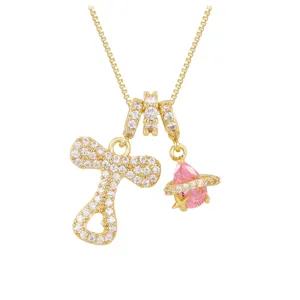 Close-up of gold-plated necklace with pavé zirconia letter R and pink Saturn pendant