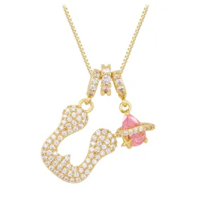 Detailed macro view of gold-plated letter J necklace with a pink Saturn-style pendant