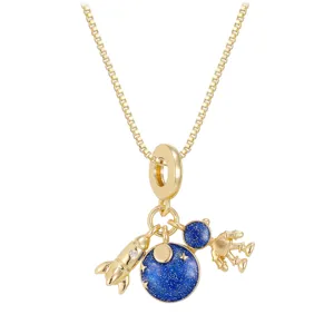 Close-up of gold space theme necklace pendant with astronaut and blue starry planet