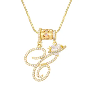 Detail van een gouden ketting met letter C en een schitterende hartvormige Saturnus-hanger.