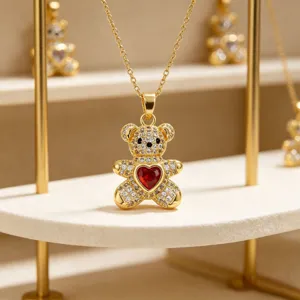 Close-up of gold teddy bear pendant necklace with micro-pave zircons and red heart.