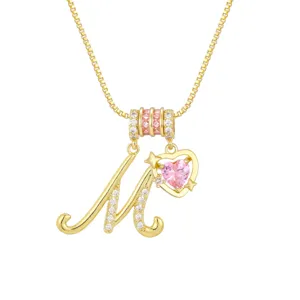 Detaillierte Ansicht der Goldkette mit kursivem M-Anhänger und rosa Herz-Stein