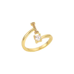 Vue détaillée d'une bague ouverte dorée avec une lettre I scintillante et un cristal
