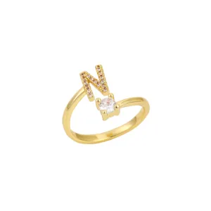 Vue détaillée de la bague ouverte dorée avec la lettre N et une pierre en oxyde de zirconium