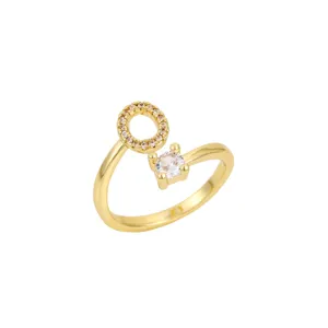Vue rapprochée d'une bague ouverte dorée avec la lettre 'O' et zircons brillants