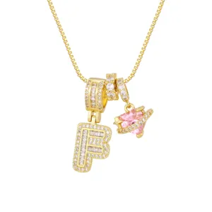 Détail du collier plaqué or 18K avec cœur en zircon rose et pendentif lettre F étincelant.