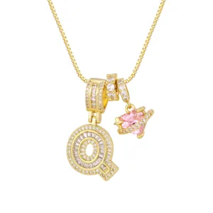 Gros plan détaillé d'un collier plaqué or avec un cœur rose et un pendentif lettre Q