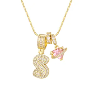 Détail d'un collier plaqué or 18K avec initiale S en CZ et pendentif cœur en zircon rose.