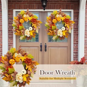 Close-up of autumn door wreath with faux maple leaves and pumpkins on a front door