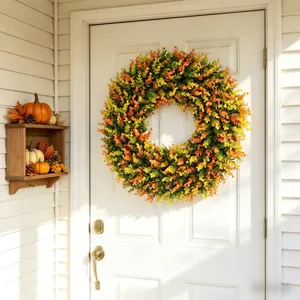 Fall-themed artificial eucalyptus wreath hanging on a white front door as home decor