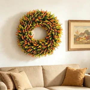 Cozy home interior with artificial boxwood wreath hanging on white wall above beige sofa